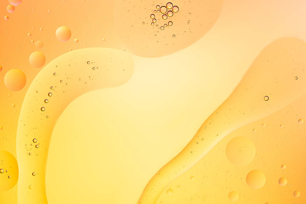 Abstract macro background of oil bubbles on water yellow and gold color with copy space - Fotoğraf, Görsel