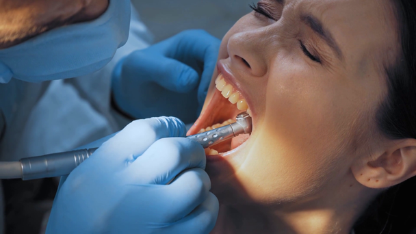 診療所で痛みを感じながら歯科器具を使う歯科医師  - 映像、動画
