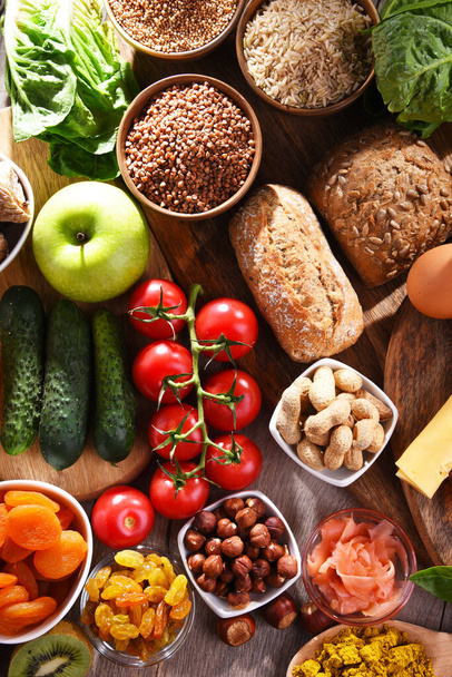 Композиція з різноманітними органічними продуктами харчування на дерев'яному кухонному столі
. - Фото, зображення