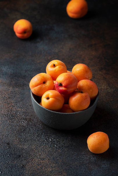 Concept of healthy vegan food with sweet apricots in a dark background, selective focus image - Fotó, kép