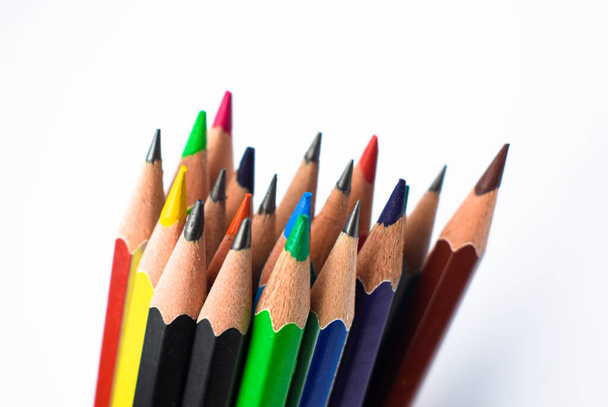 Different colored wood pencil crayons stocked together on an empty white background - Foto, imagen