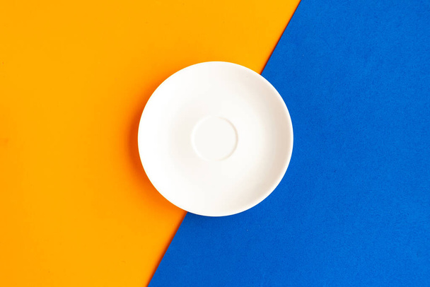 Prázdný talíř na oranžovém a modrém pozadí. Zkopírovat místo pro text. Minimální koncepce - Fotografie, Obrázek