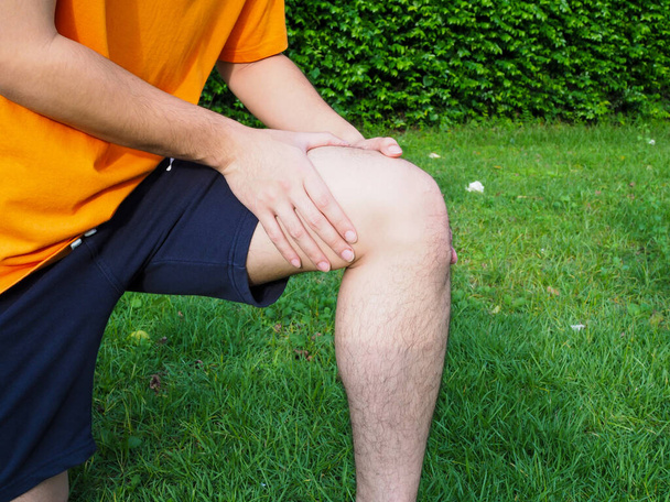 Persone con dolore alle gambe, infiammazione muscolare e dolore al ginocchio con camminare in giardino - Foto, immagini