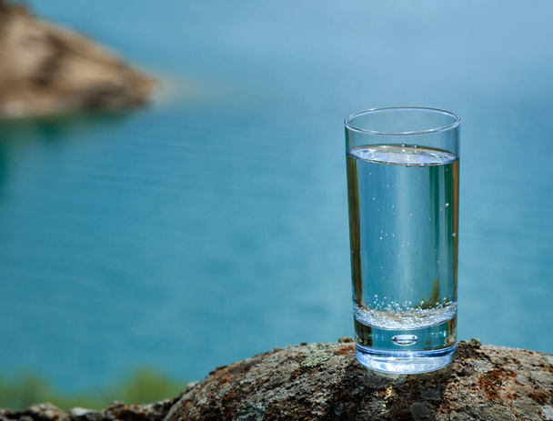 天然の背景に澄んだ水のガラス - 写真・画像
