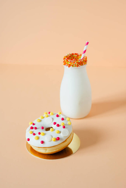 delicious donuts and a glass of milk.Isolated on a peach background. High quality photo - Foto, immagini