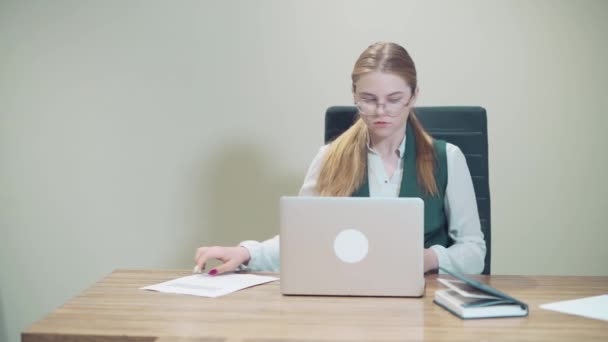 Young beautiful business woman sits at the workplace and opens her diary. - Video, Çekim