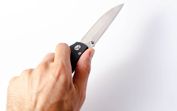 Cuchillo plegable con mango negro sobre fondo blanco, abierto y cerrado. Cordón de paracord en el cuchillo. Cuchillo táctico plegable en primer plano. Cuchillo en la mano de un hombre
 - Foto, Imagen