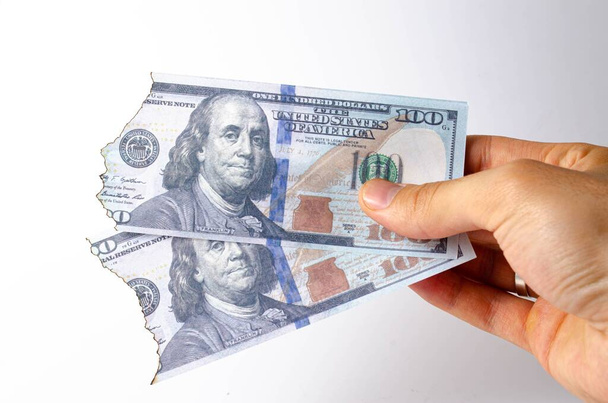 Dólares estadounidenses en la mano de un hombre en una vista en primera persona de fondo blanco. Dólares quemados. Los dólares están ardiendo, cenizas, fuego
 - Foto, imagen