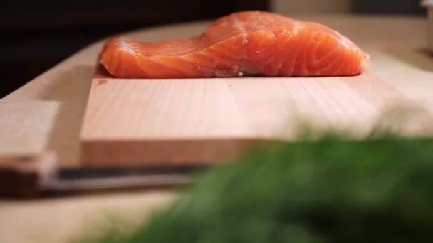 Saumon pelé cru sur une planche à découper. Filet de saumon frais sur la table. - Séquence, vidéo