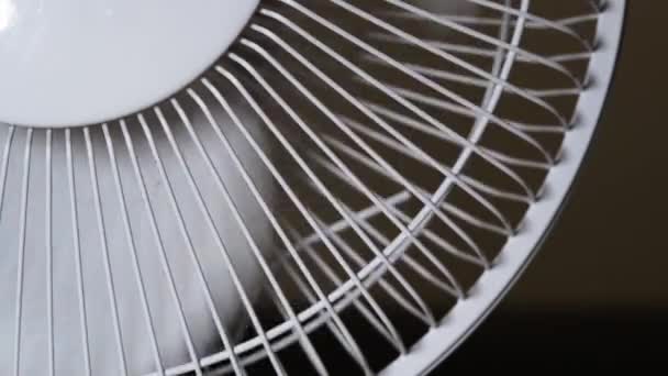 De huishoudelijke ventilator stopt om de bladen te roteren. Een bewegende ventilator om je af te koelen op een warme zomerdag. - Video
