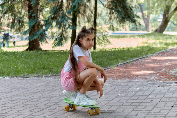 The girl is actively involved in sports and rides a skateboard. Sports lifestyle - Φωτογραφία, εικόνα