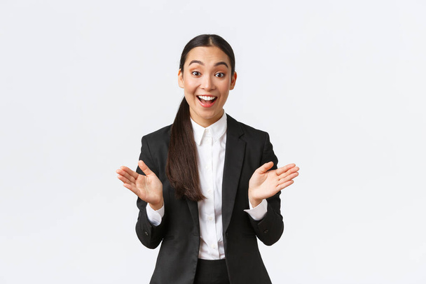 Щаслива азіатська жінка-бізнесмен реагує на великі новини, піднімаючи руки, аплодуючи і конгреси з великими продажами, похвали член команди. Веселий підприємець у костюмі радіє
 - Фото, зображення