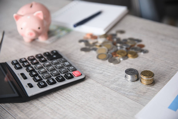 piggy bank with coins and calculator on des - Foto, Imagem