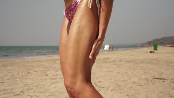 Bronzé belle femme sur la plage utilise un agent de bronzage - Séquence, vidéo