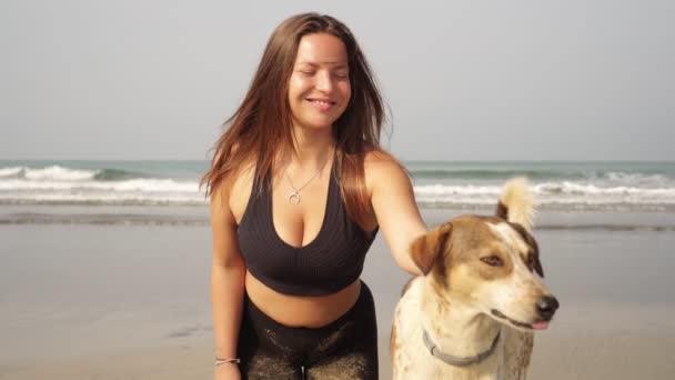 屋外で犬と若い女性の肖像画。浜の少女と犬 - 映像、動画
