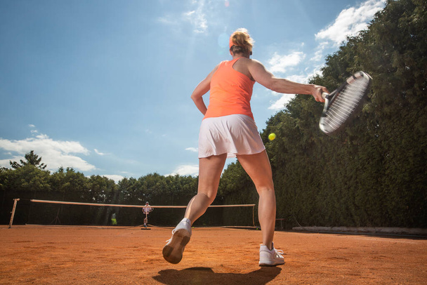 ženský tenista trénink s trenérem na hliněném hřišti, sportovní koncept - Fotografie, Obrázek