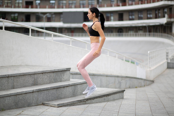 Mujer joven fitness lleva ropa deportiva en su entrenamiento en el estadio - Foto, Imagen