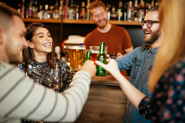 Groupe d'amis boire de la bière, bavarder et s'amuser au pub. - Photo, image