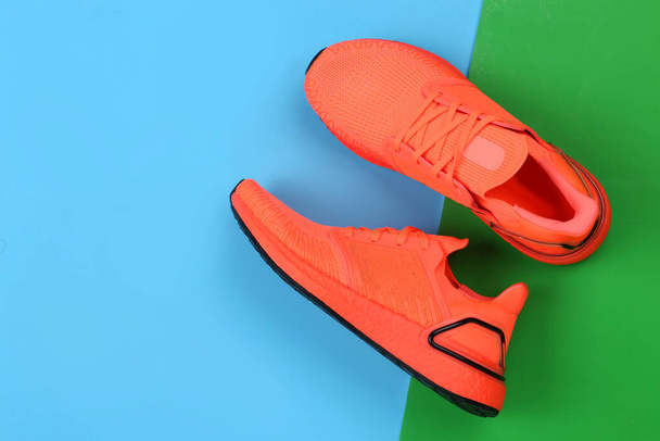 Renkli arka planda bir çift spor ayakkabısı. Boşluğu kopyala. Koşu ayakkabılarının yukarıdan çekimi. Üst manzara, düz uzanma - Fotoğraf, Görsel