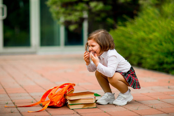 Little girl in school uniform and glasses, with textbooks - Foto, Imagen