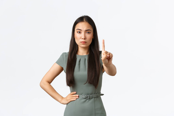 Koncepcja małych przedsiębiorstw, kobiet przedsiębiorców. Ścisłe poważne azjatyckie businesswoman w sukienka zbesztanie pracownika, patrząc rozczarowany i wstrząsający palec, nie zgadzają się, zakazać działania - Zdjęcie, obraz