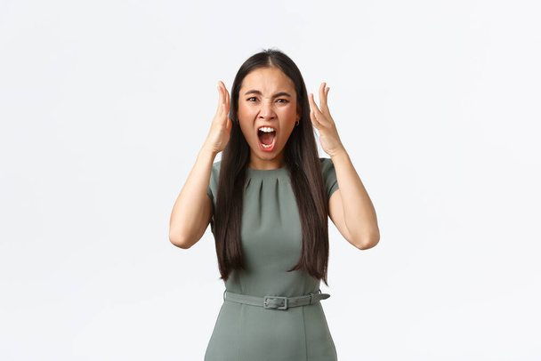 Small business owners, women entrepreneurs concept. Mad and pissed-off aggressive asian businesswoman shouting, looking frustrated and disappointed, shaking hands, being cheated on - Fotoğraf, Görsel