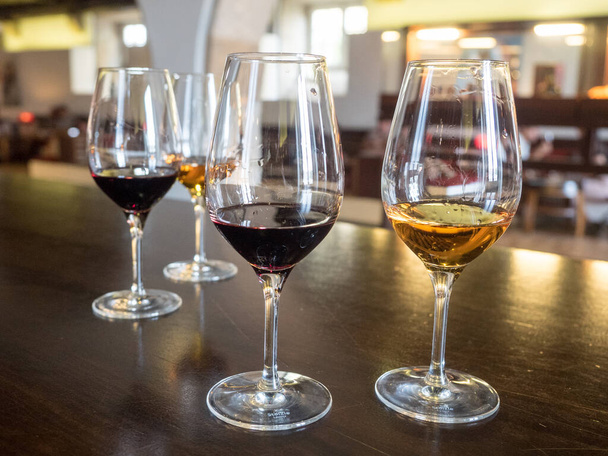 rode en witte wijn port sherry in glazen. Porto en wijnproeverij in de porto kelders van porto portugal - Foto, afbeelding