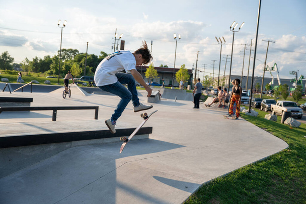 Детройт, штат Мичиган, США - 7.24.2020: Скейтбордисты и байкеры тренируются в открытом скейт-парке во время короны в Детройте. - Фото, изображение