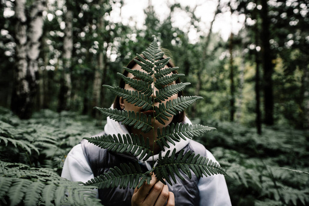 girl with leaf of fern in siberian forest - Foto, Imagem