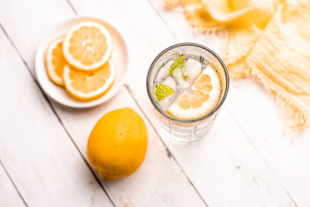 Cold Detox Water with lemon slices and mint on a white wood table - 写真・画像