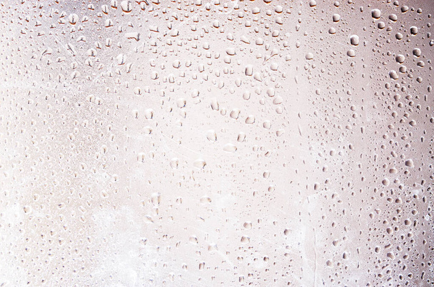 Gotas de agua sobre un fondo borroso en primer plano. Gotas de lluvia sobre un fondo al atardecer. Agua sobre vidrio. Gotas cuelgan
 - Foto, Imagen