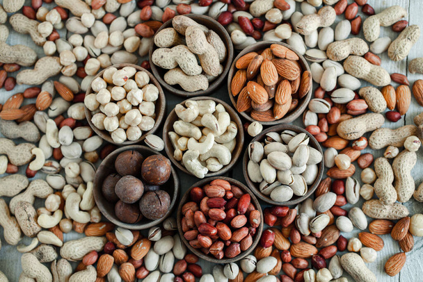 Assorted nuts for a backgroundAlmond, walnut,cashew, pistachios, hazelnuts, peanuts, MacadamiaCollection of different varieties of nuts. Composition with dried fruitsHealthy food. Organic. - Фото, зображення
