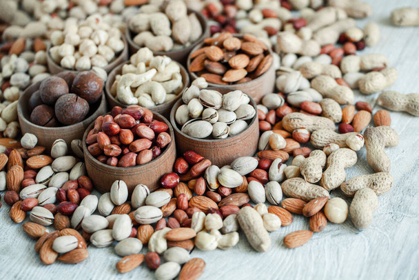 Assorted nuts for a backgroundAlmond, walnut,cashew, pistachios, hazelnuts, peanuts, MacadamiaCollection of different varieties of nuts. Composition with dried fruitsHealthy food. Organic. - Foto, afbeelding