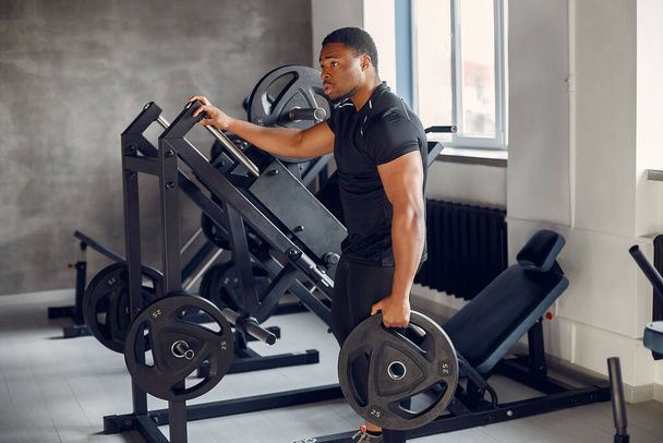 A handsome black man is engaged in a gym - Valokuva, kuva