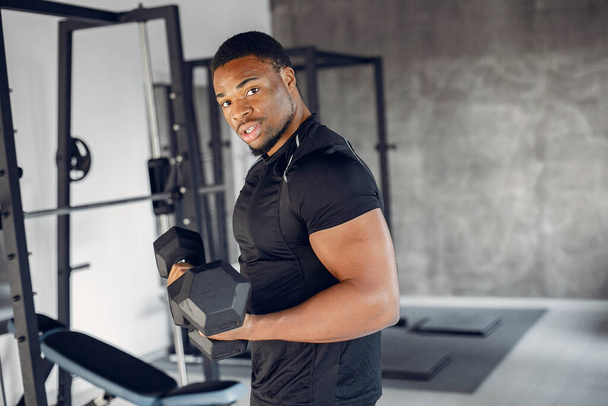 Przystojny czarny mężczyzna jest zaangażowany w siłowni - Zdjęcie, obraz