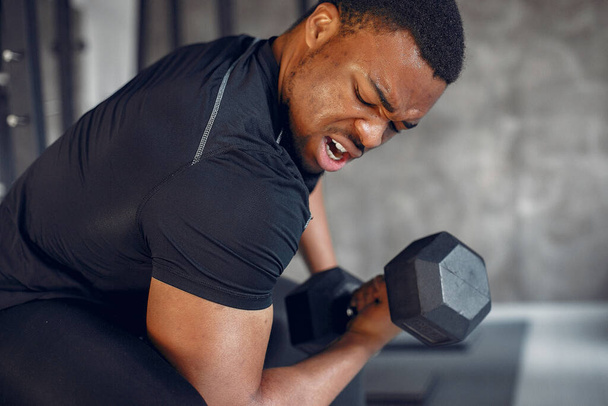 A handsome black man is engaged in a gym - 写真・画像