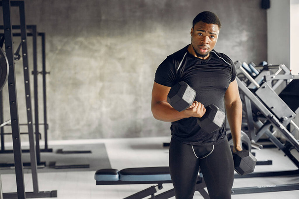 A handsome black man is engaged in a gym - Foto, afbeelding