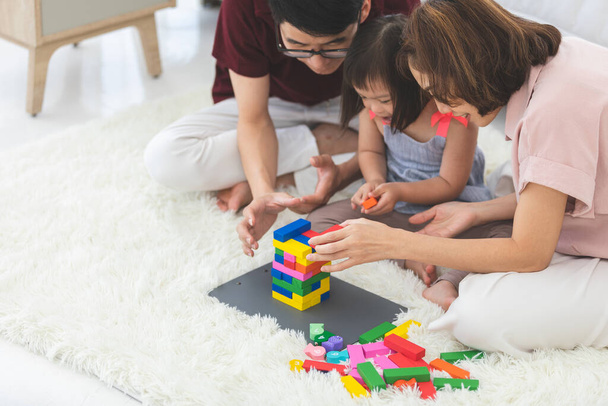 Niña con discapacidades de aprendizaje O el grupo de síndrome de dow está aprendiendo sobre juguetes de madera de colores con la enseñanza familiar y alentador al lado. Educación concepto especial
. - Foto, Imagen