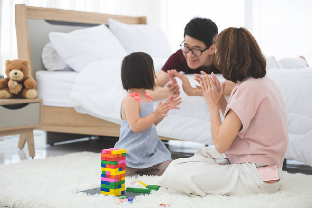  A tanulási nehézségekkel küzdő kislány vagy a Dow-szindróma egy csoportja a színes fa játékokról tanít és bátorít a család mellett. Az oktatás speciális koncepciója. - Fotó, kép