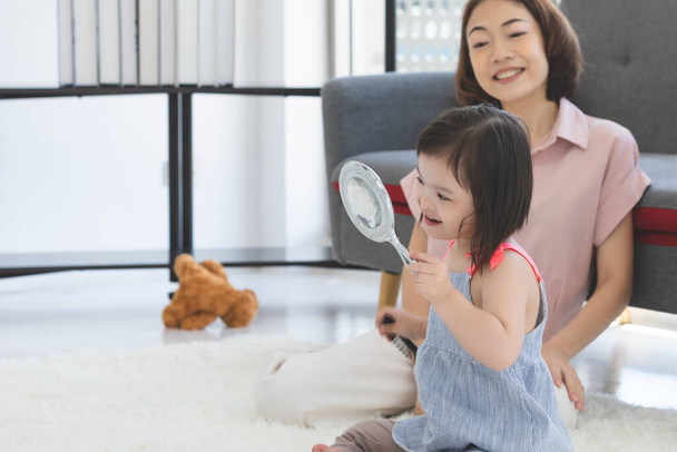 Aasialainen perhe lääketieteellisissä naamioissa kasvoilla katsoo kameraa seistessään kotona olohuoneessa estääkseen PM2,5-pölyä, sumua, ilmansaasteita ja COVID-19: tä. Terveydenhuollon käsite. - Valokuva, kuva
