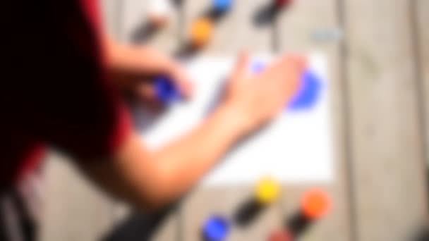 Rozmazané pozadí. Dívka prsty rozmazání gouache barva, inkoust na bílém papíru, - Záběry, video