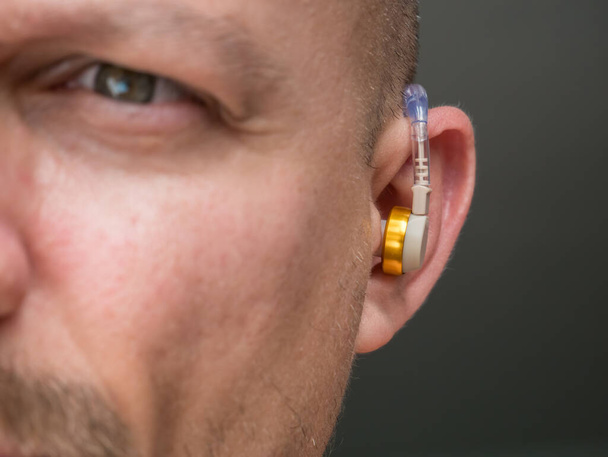 Audífono en el oído de un hombre con sordera y discapacidad auditiva
. - Foto, Imagen