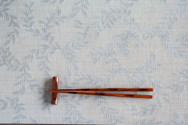 Traditional japanese chopsticks on chopstick rest on plate mat - Photo, Image