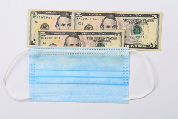 Медицинская хирургическая маска и мелкие доллары. Фон. - Фото, изображение
