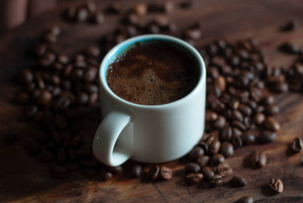 Біла чашка з кавою з кавовими зернами
 - Фото, зображення