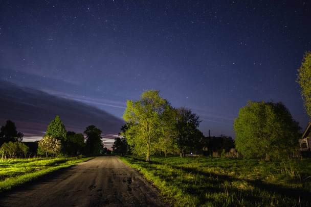 Starry sky over the road in the village - Foto, afbeelding