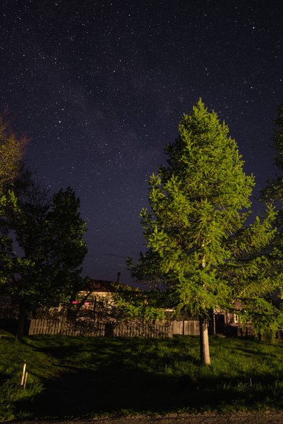 Typowy dom w rosyjskiej wiosce w nocy przed gwiaździstym niebem z  - Zdjęcie, obraz