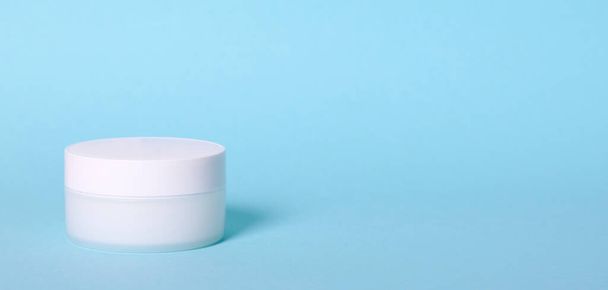 White cream container. Isolated on blue background. - Photo, Image