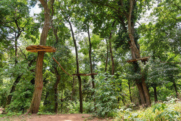 Treetop Obstacle Course Adventure Park. Vista del parque de aventura escalada en las barreras forestales
. - Foto, imagen