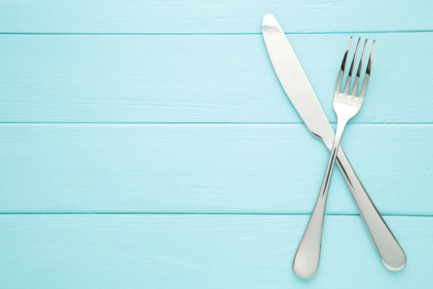 Fork and knife on a blue background. Top view - Valokuva, kuva
